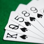 poker hand of playing cards on green casino cloth